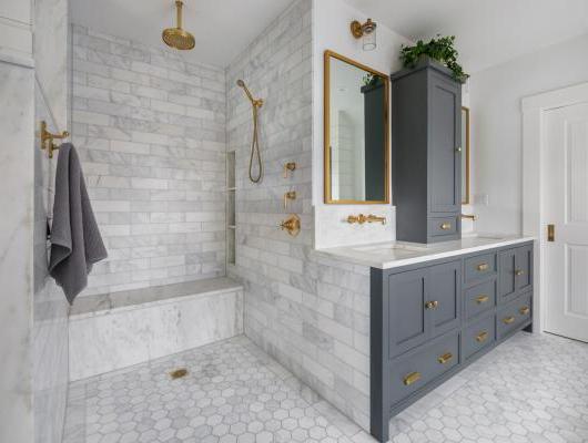 改建的主浴室配有白色大理石和未上漆的黄铜装置 
